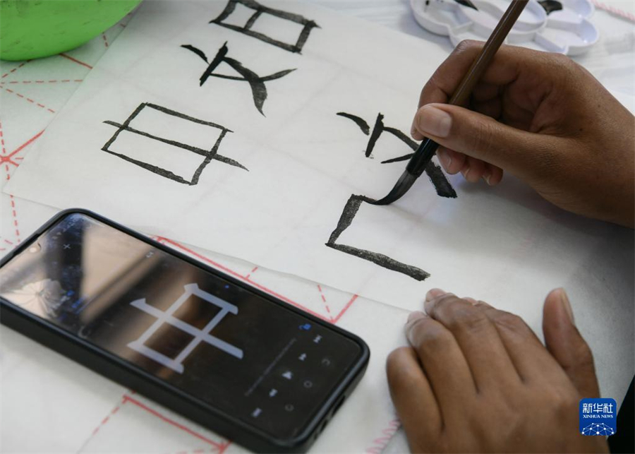 4月18日，肯尼亞學(xué)生在內(nèi)羅畢大學(xué)孔子學(xué)院舉辦的活動(dòng)上寫毛筆字。肯尼亞內(nèi)羅畢大學(xué)孔子學(xué)院18日舉辦“中文，增進(jìn)文明對話”主題活動(dòng)，慶祝即將到來的第14個(gè)聯(lián)合國中文日。肯尼亞學(xué)生參與互動(dòng)，進(jìn)行書法、剪紙、唱中文歌等活動(dòng)。新華社記者 韓旭 攝