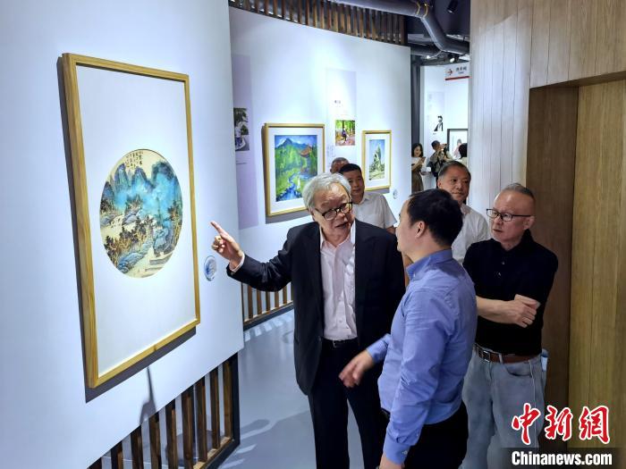 海峽兩岸藝術(shù)家畫展上，藝術(shù)家進行藝術(shù)交流?！「毒窜?攝