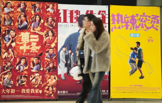 這是2月17日，在沈陽一家影院，觀眾從海報前經(jīng)過。新華社記者李鋼攝