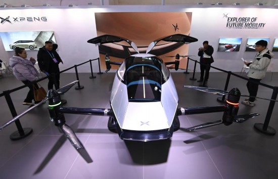2023年12月1日，在鏈博會智能汽車鏈展區小鵬汽車展臺，參觀者觀看一臺智能飛行器。新華社記者蔡湘鑫攝