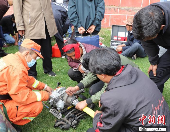圖為森林消防員為護林員講解滅火裝備的使用方法。　昌都市森林消防支隊 供圖