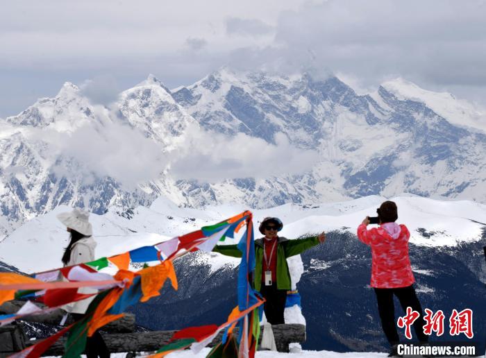 圖為5月14日，西藏林芝色季拉山觀景臺(tái)，游客與南迦巴瓦峰合影。　李林 攝
