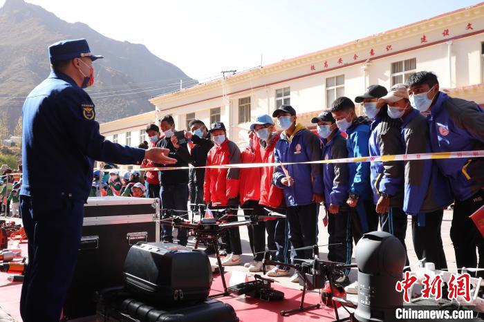 圖為消防指戰(zhàn)員為學(xué)生講解、演示先進(jìn)救援裝備?！≮w琳 攝