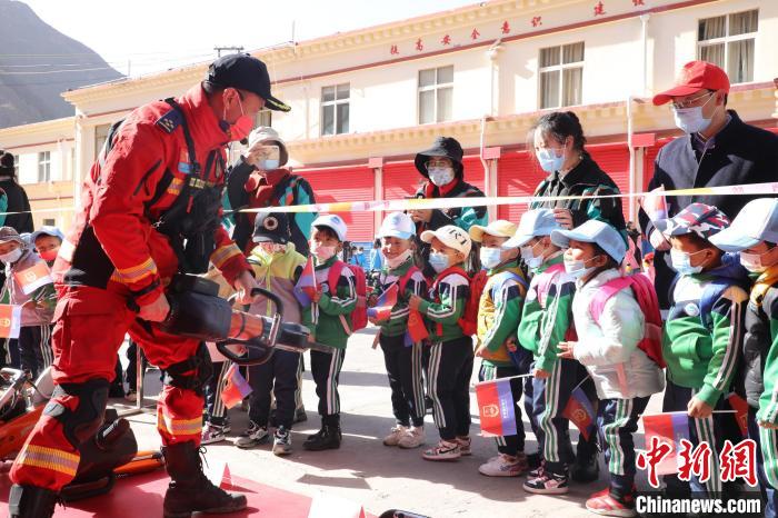 圖為消防指戰(zhàn)員為學(xué)生講解、演示先進(jìn)救援裝備。　趙琳 攝