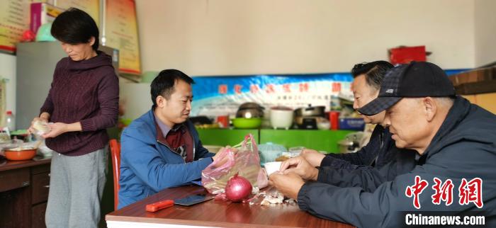 圖為扶貧路上“臨時一家人”準(zhǔn)備午餐?！∥航ㄜ?攝
