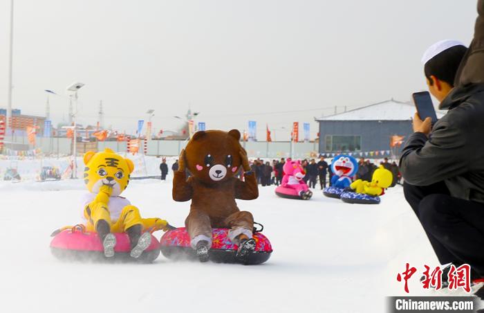 圖為臨夏市南龍鎮(zhèn)馬家莊村舉辦的鄉(xiāng)村文化旅游節(jié)上，游客穿著卡通服裝在體驗雪上飛碟項目。近年來，臨夏州形成了“春賞花、夏避暑、秋摘果、冬玩雪”的全季節(jié)旅游產(chǎn)品體系。(資料圖) 高展 攝