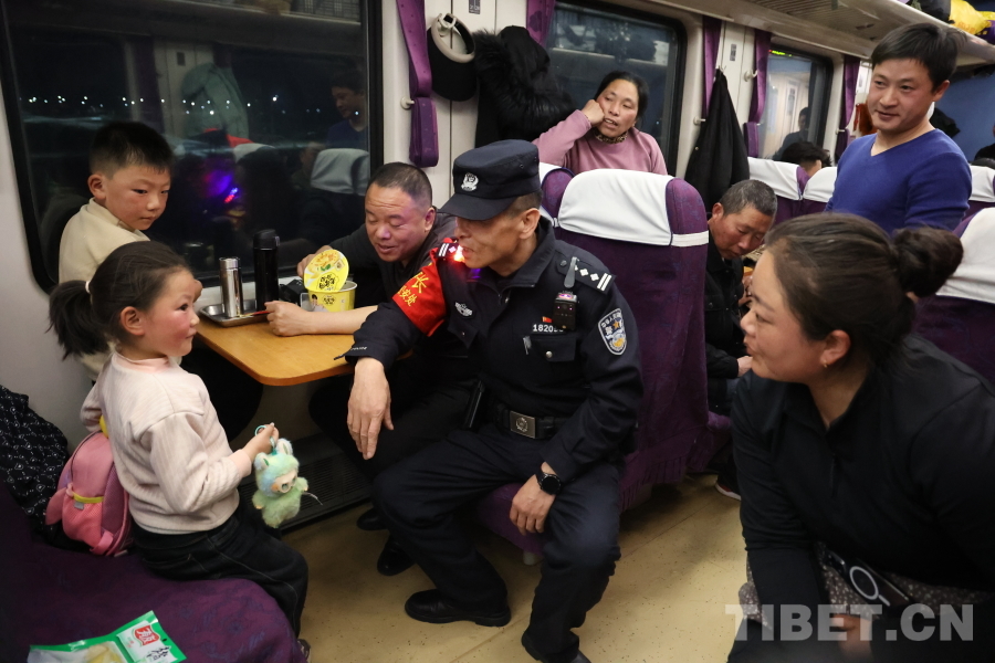 乘警長左紅彬在巡視車廂間隙，向攜帶兒童的旅客專門叮囑安全注意事項。.JPG